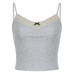 Grey ribbed cami top with lace trim and a black bow, paired with jeans for a chic, casual look.