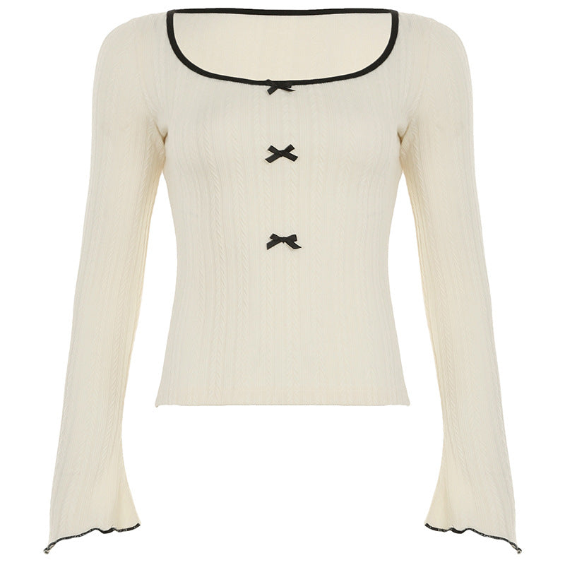 Ribbed knit long-sleeve top with black bow accents and contrasting trim, featuring a scoop neckline for a feminine and chic look.

